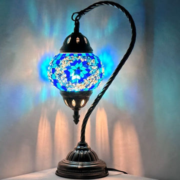 Blue handmade Turkish mosaic glass swan-neck table lamp glowing on a desk