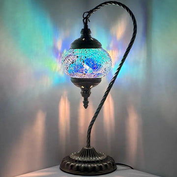 A swan-neck Turkish-style mosaic glass table lamp with a curved gooseneck stem and a glowing mosaic globe