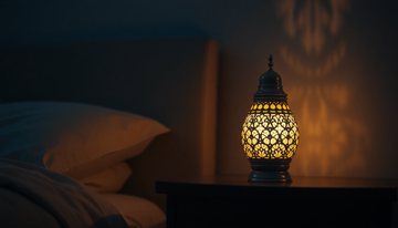 A soft silver-toned Turkish mosaic glass night lamp glowing gently on a nightstand in a calm, dim bedroom at dusk