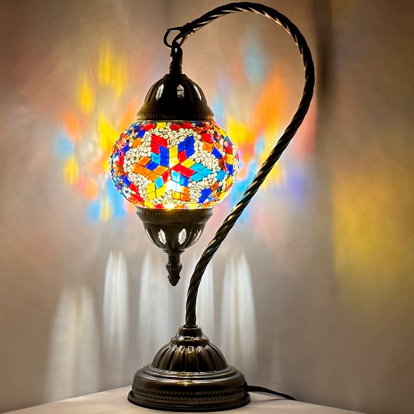 Moroccan Essence mosaic glass table lamp — glowing against a dark background