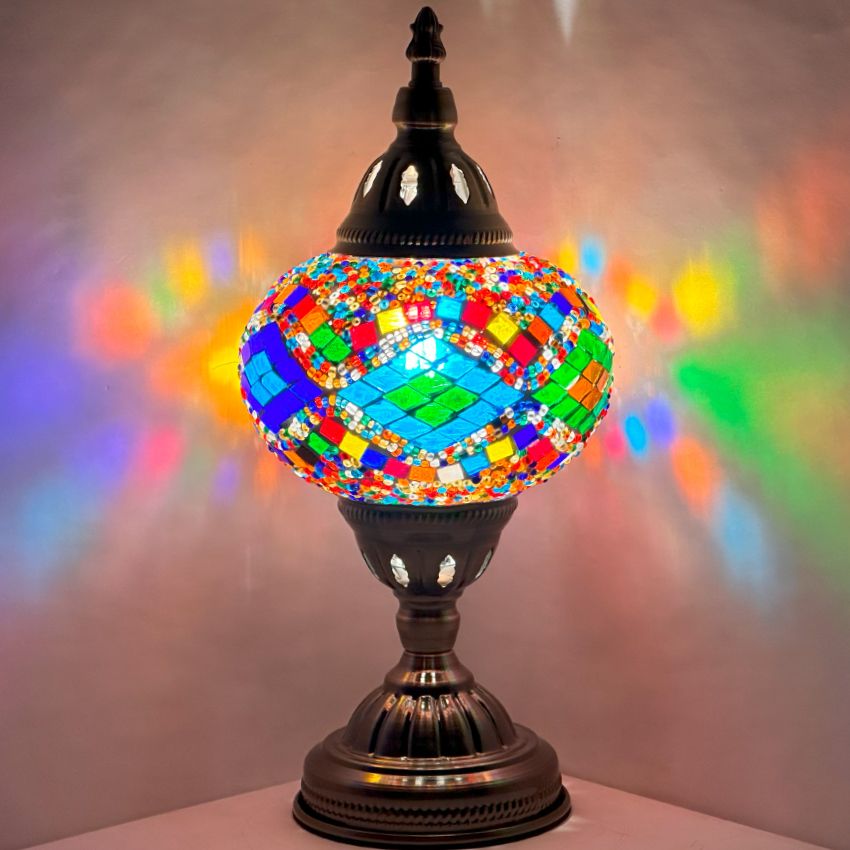Kaleidoscopic Diamond Road mosaic glass table lamp — glowing against a dark background