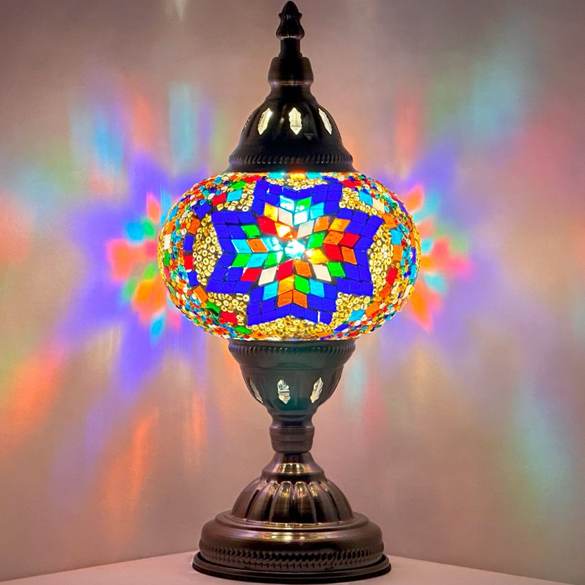 Moroccan Sunset mosaic glass table lamp — glowing against a dark background