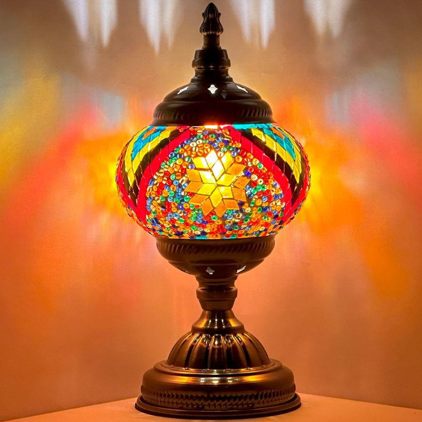 Floral Spectacle mosaic glass table lamp — glowing against a dark background
