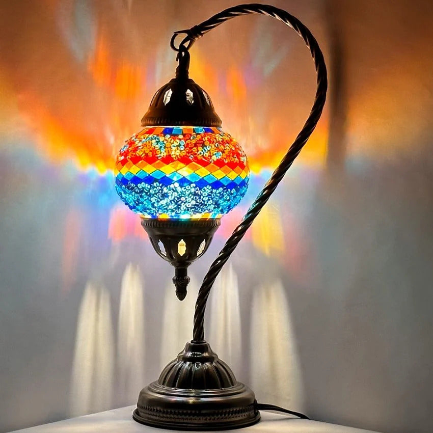 Iridescent Swan Neck mosaic glass table lamp — glowing against a dark background