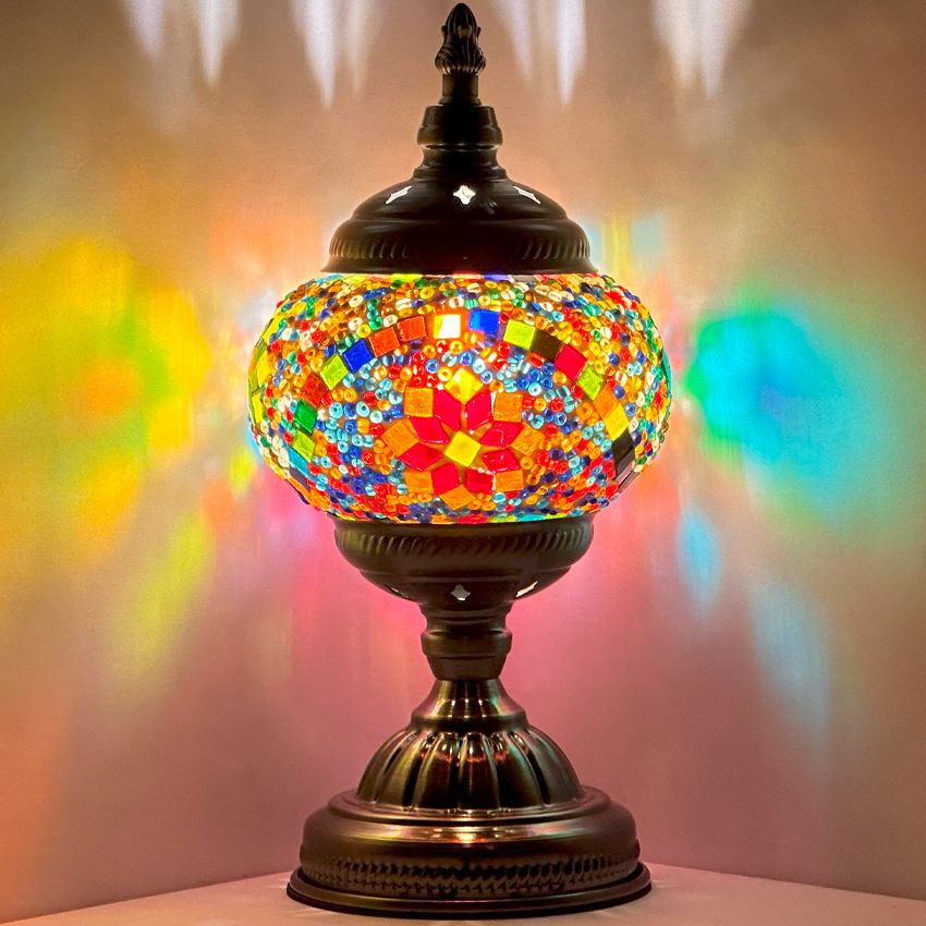 Multicolored Blossom mosaic glass table lamp — glowing against a dark background