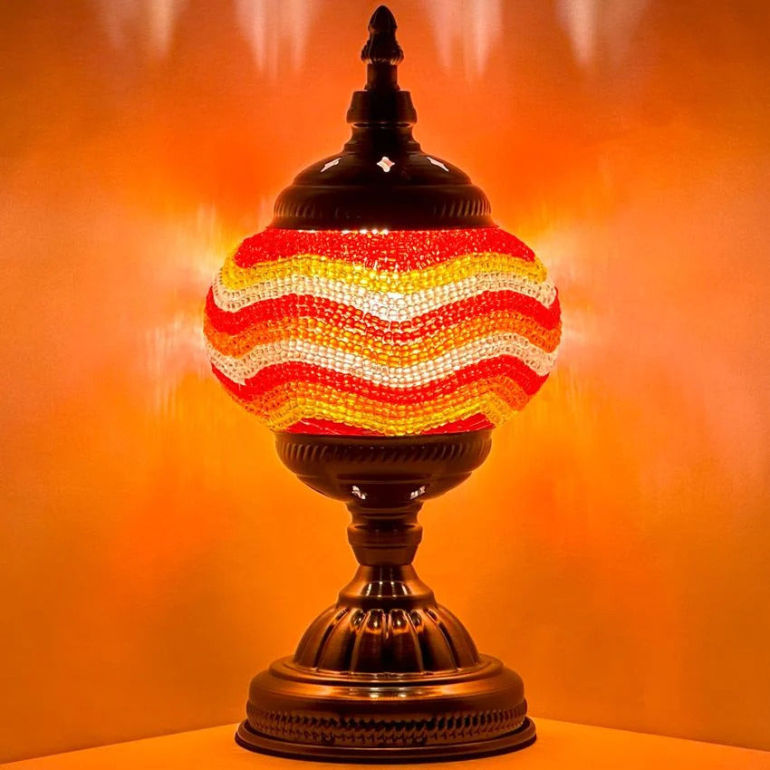 Golden Sands mosaic glass table lamp — glowing against a dark background
