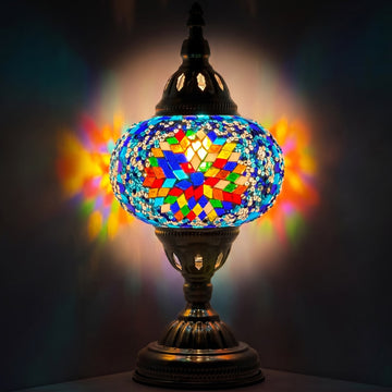 Coral Bloom mosaic glass table lamp — glowing against a deep charcoal background