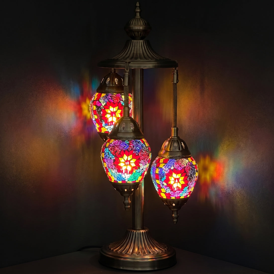 Crimson Bloom Egg mosaic glass table lamp — glowing against a deep charcoal background
