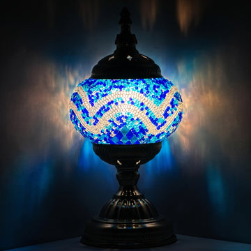 Deep Ocean blue mosaic glass table lamp glowing against a dark background