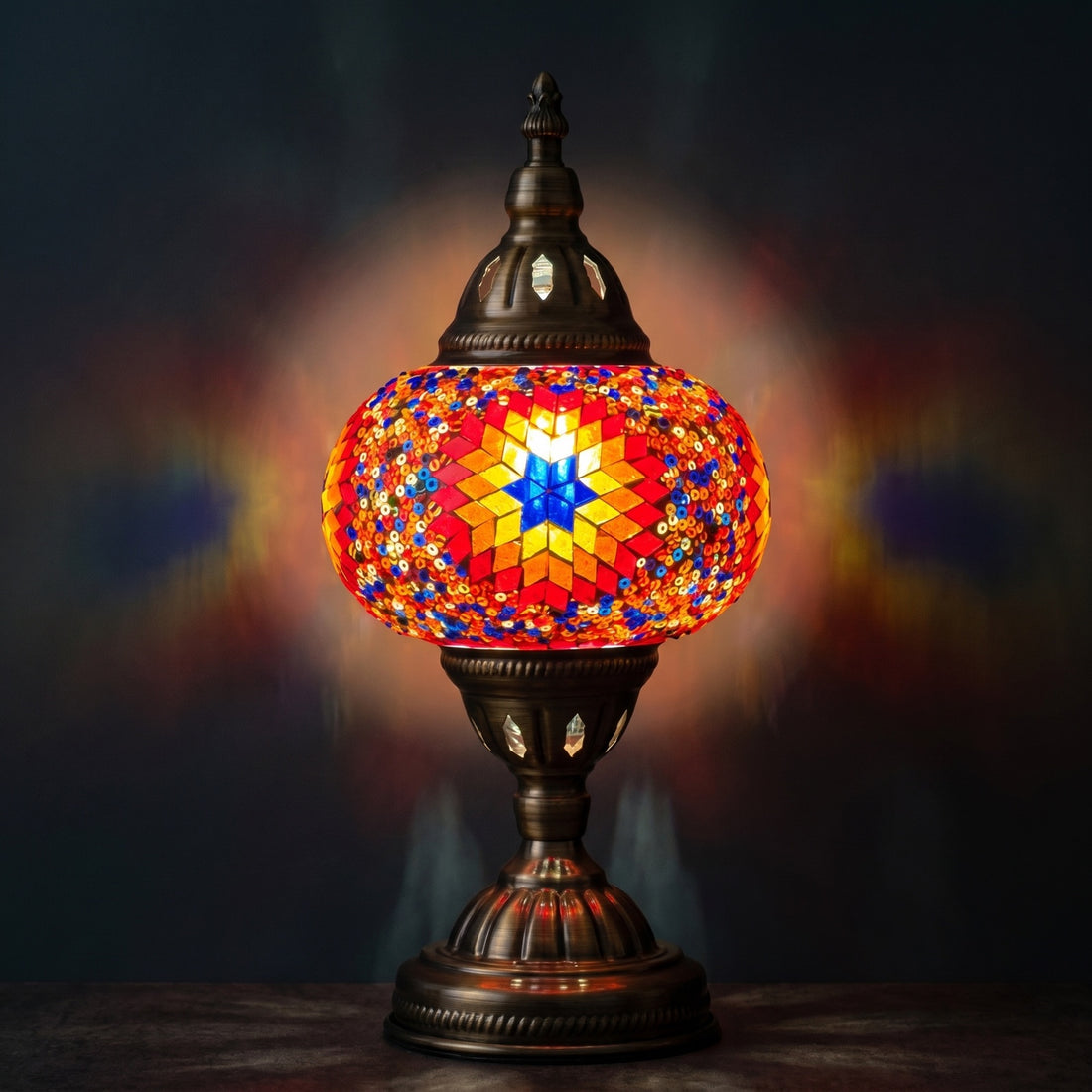Desert Bloom Mosaic mosaic glass table lamp — glowing against a deep charcoal background