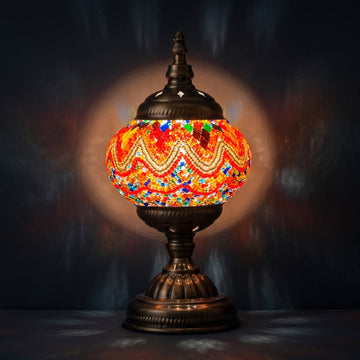 Fiery Echoes mosaic glass table lamp — glowing against a deep charcoal background