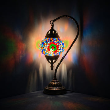 Floral Charm mosaic glass table lamp — glowing against a deep charcoal background