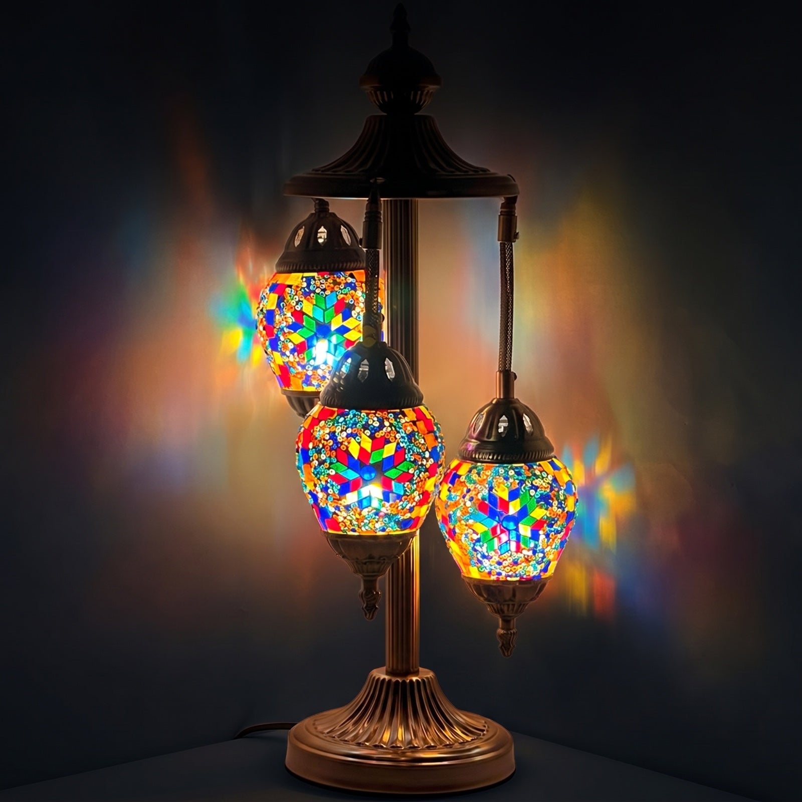 Floral Spectacle mosaic glass table lamp — glowing against a deep charcoal background