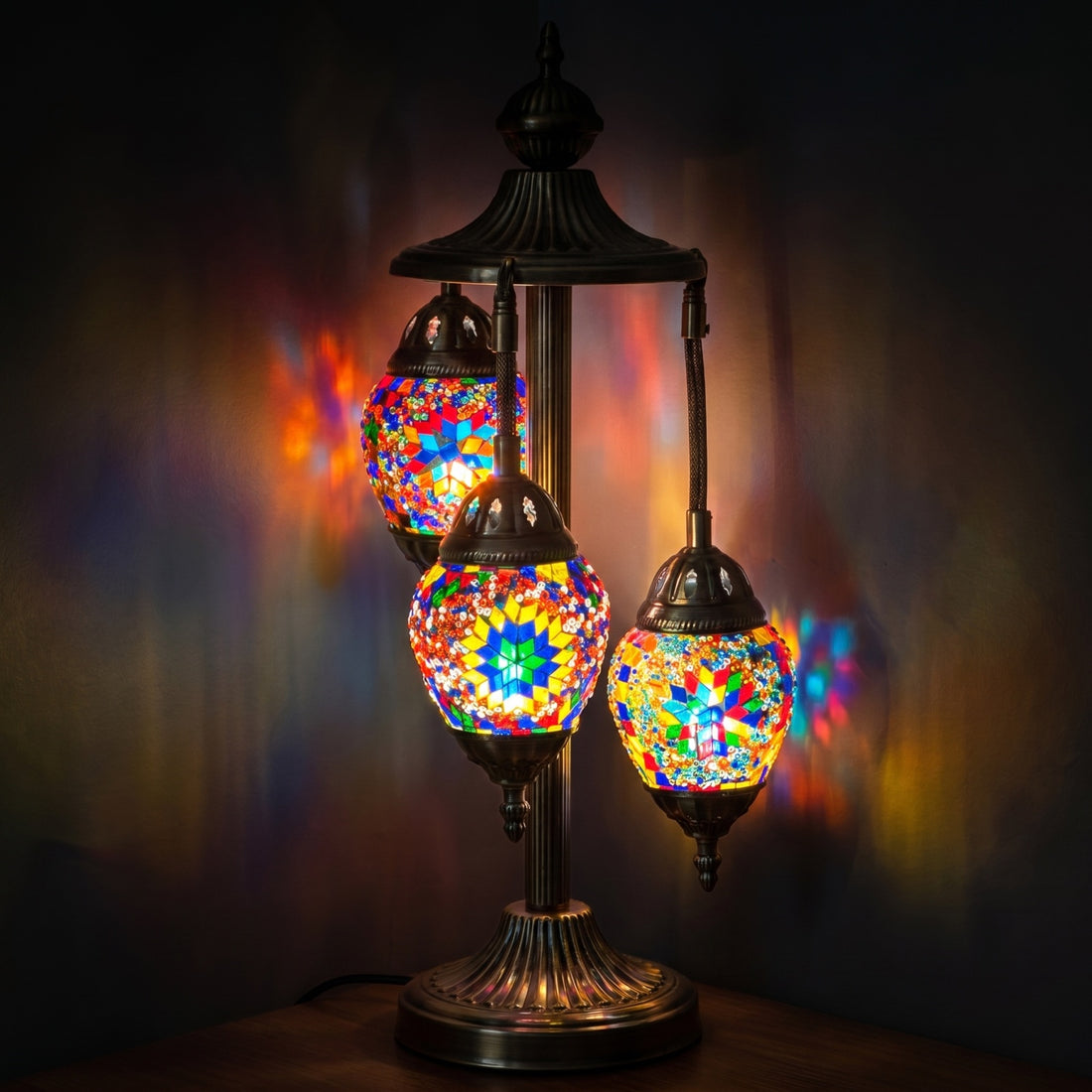 Garden Splendor mosaic glass table lamp — glowing against a deep charcoal background
