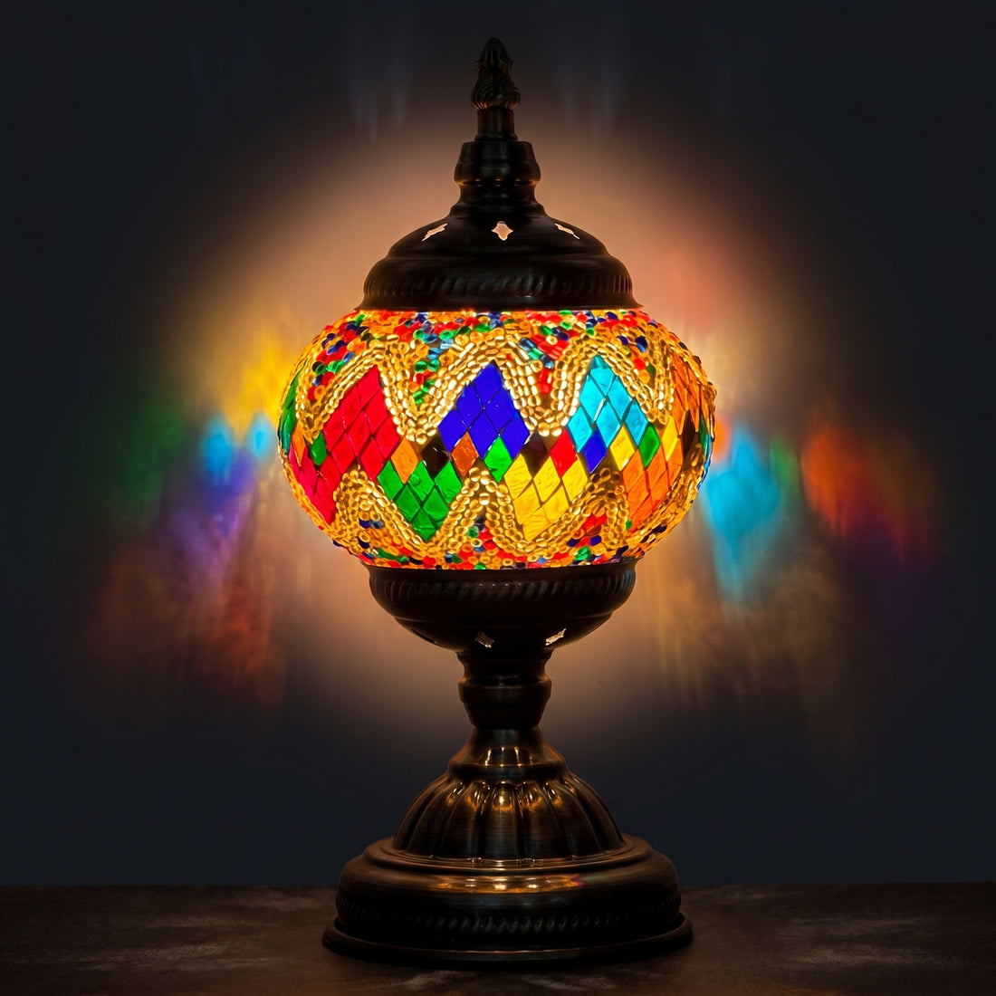 Golden Twilight mosaic glass table lamp — glowing against a deep charcoal background