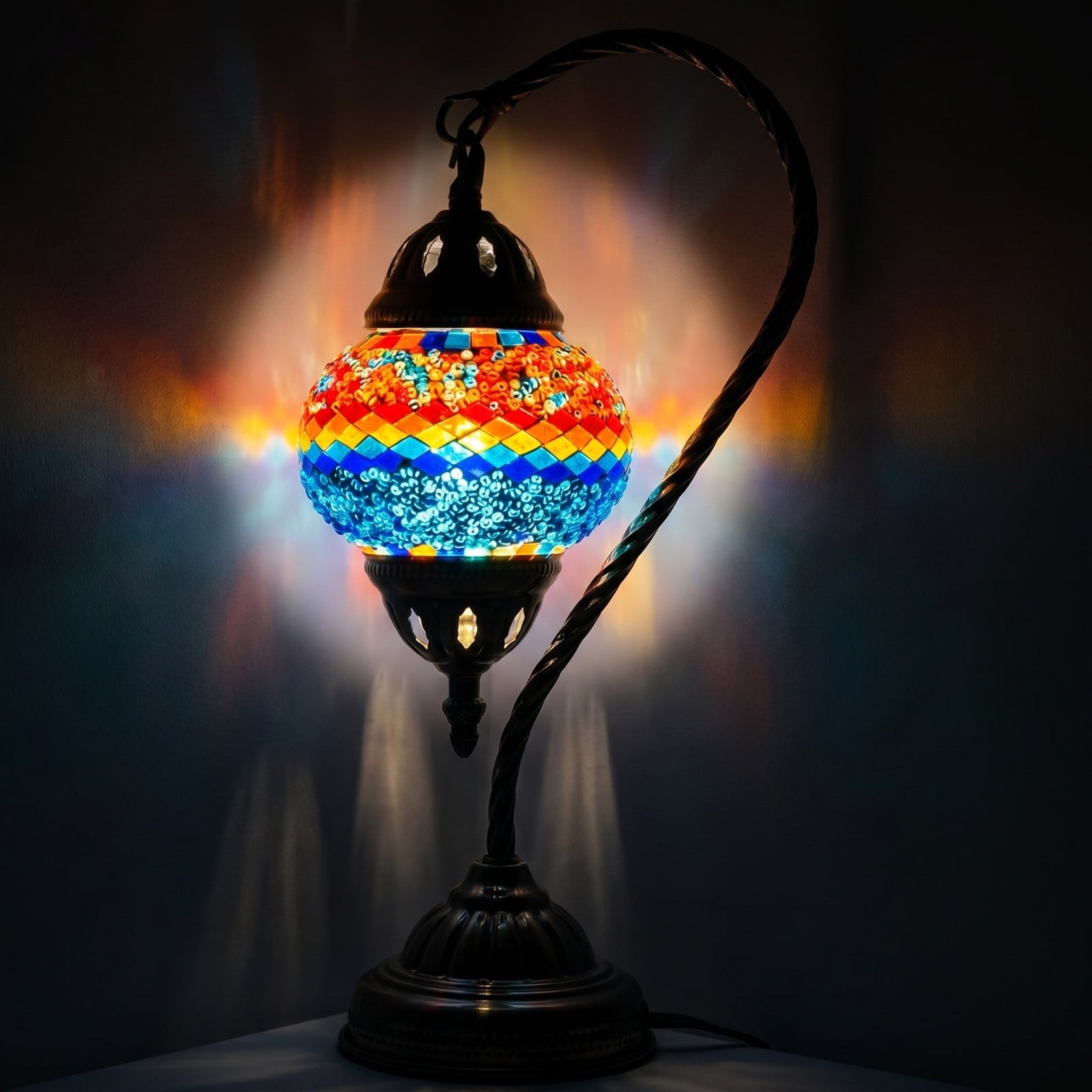 Iridescent Swan Neck mosaic glass table lamp — glowing against a deep charcoal background