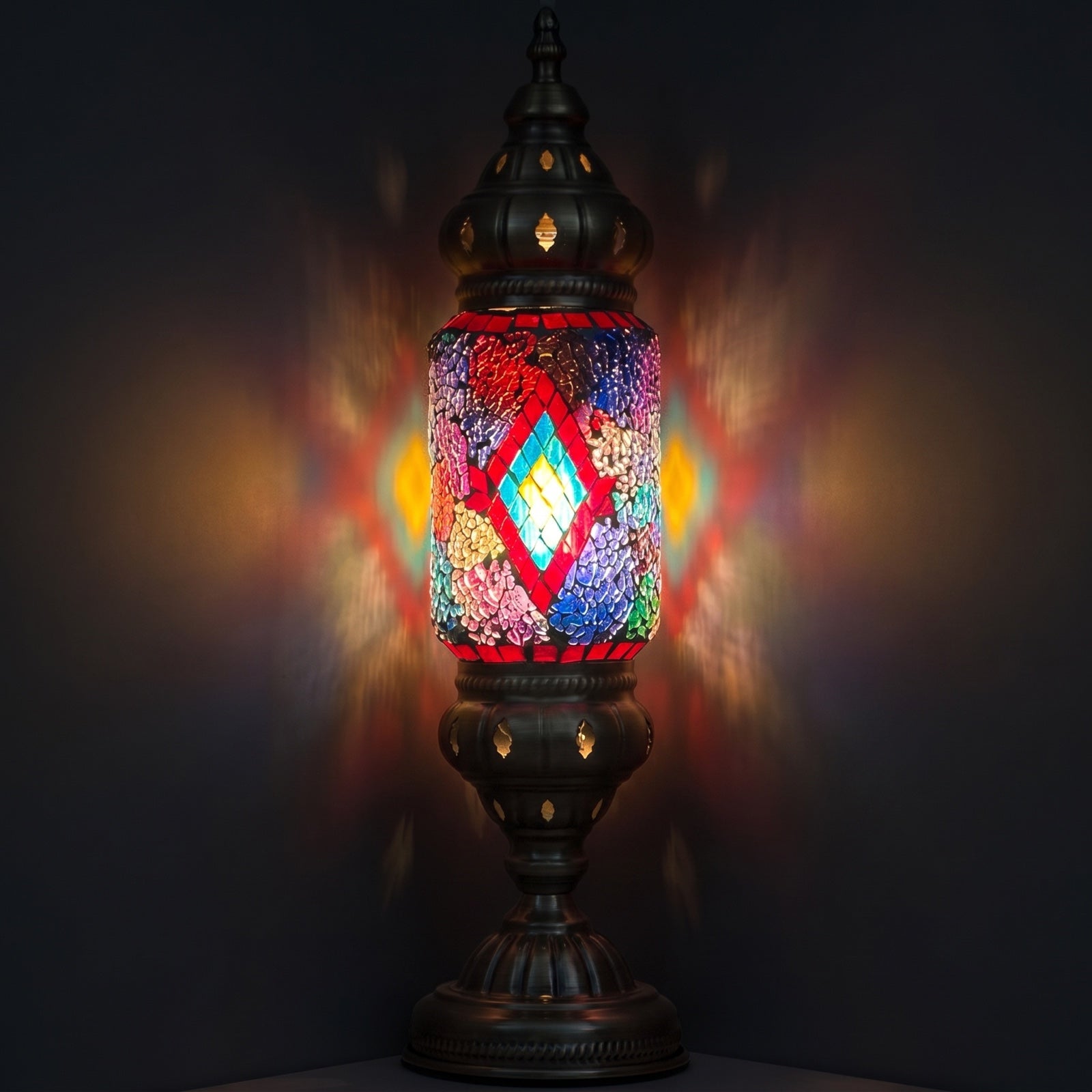 Kaleidoscope Vision mosaic glass table lamp — glowing against a deep charcoal background