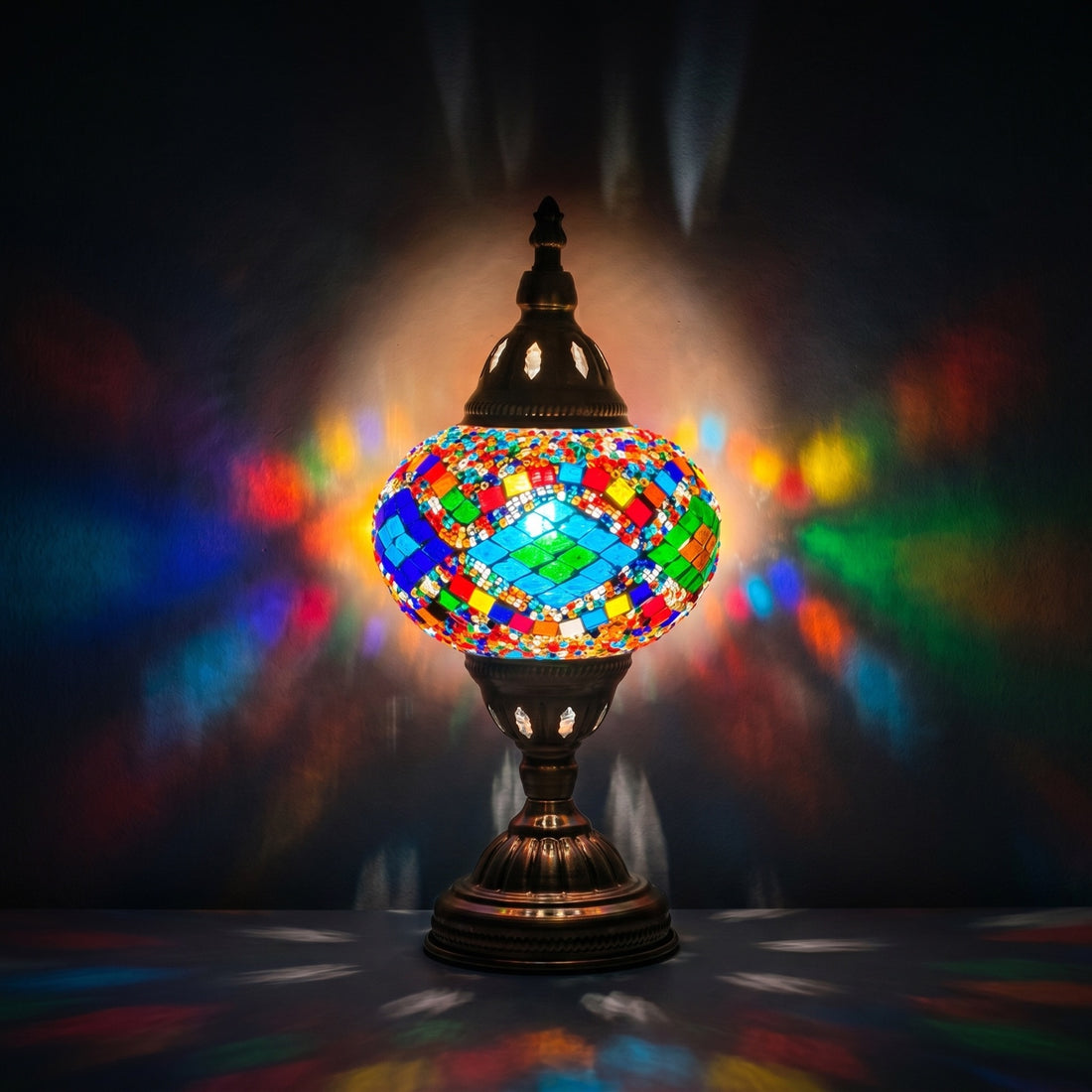 Kaleidoscopic Diamond Road mosaic glass table lamp — glowing against a deep charcoal background