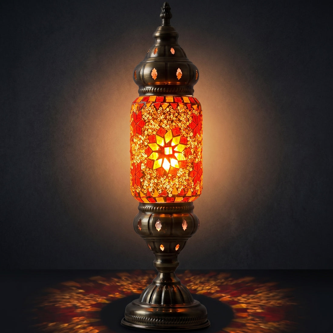 Mediterranean Allure mosaic glass table lamp — glowing against a deep charcoal background