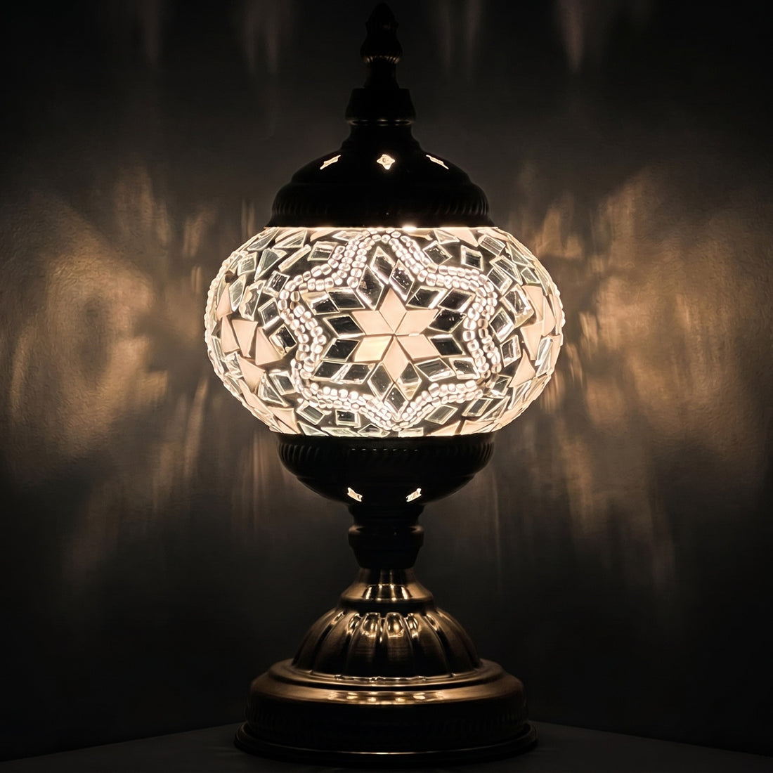 Moroccan Charm mosaic glass table lamp — glowing against a deep charcoal background