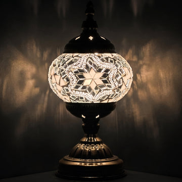 Moroccan Charm mosaic glass table lamp — glowing against a deep charcoal background