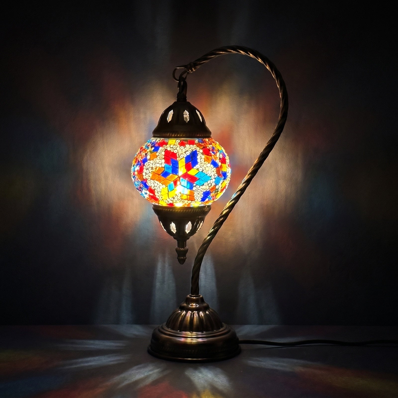 Moroccan Essence mosaic glass table lamp — glowing against a deep charcoal background