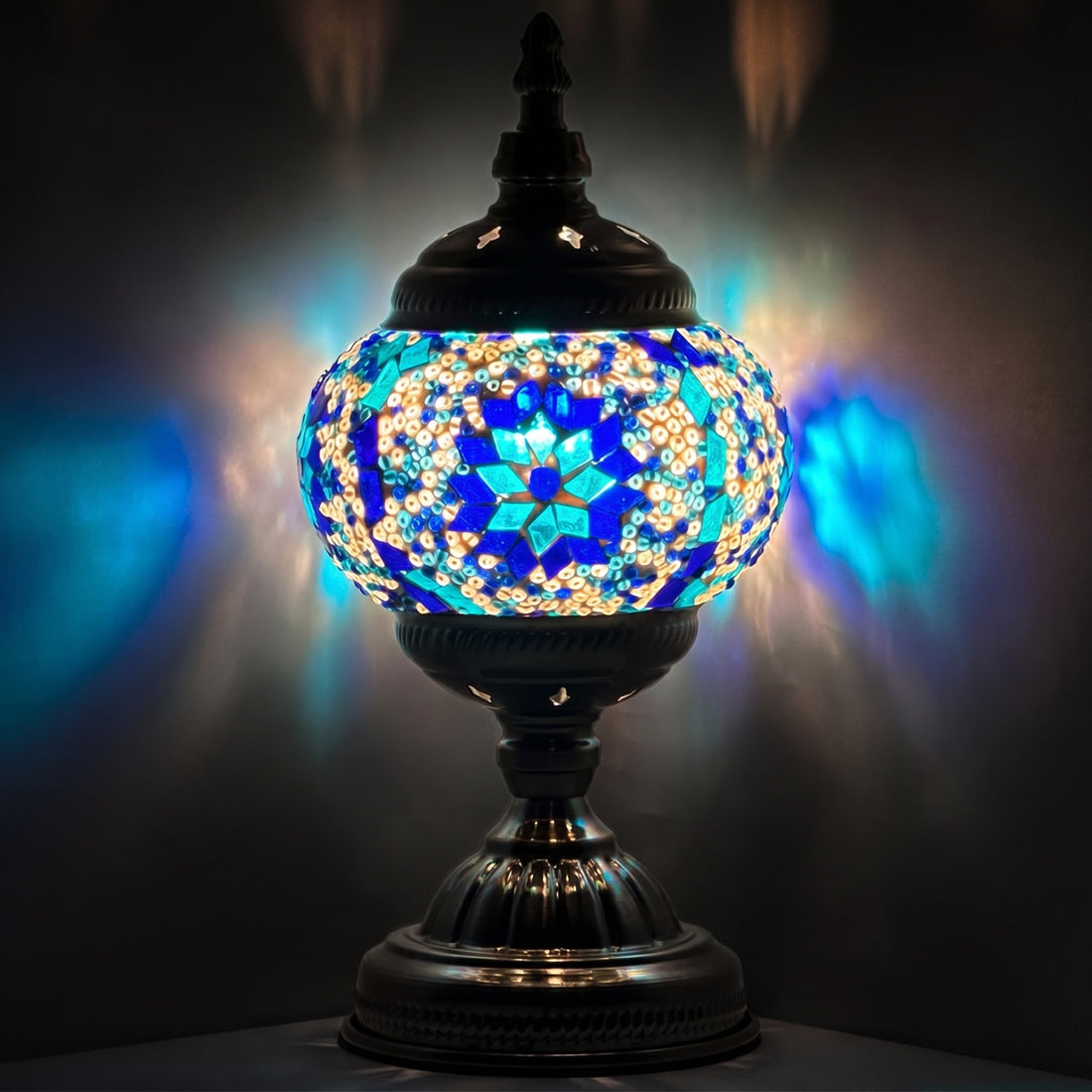 Moroccan mosaic glass table lamp — glowing against a deep charcoal background