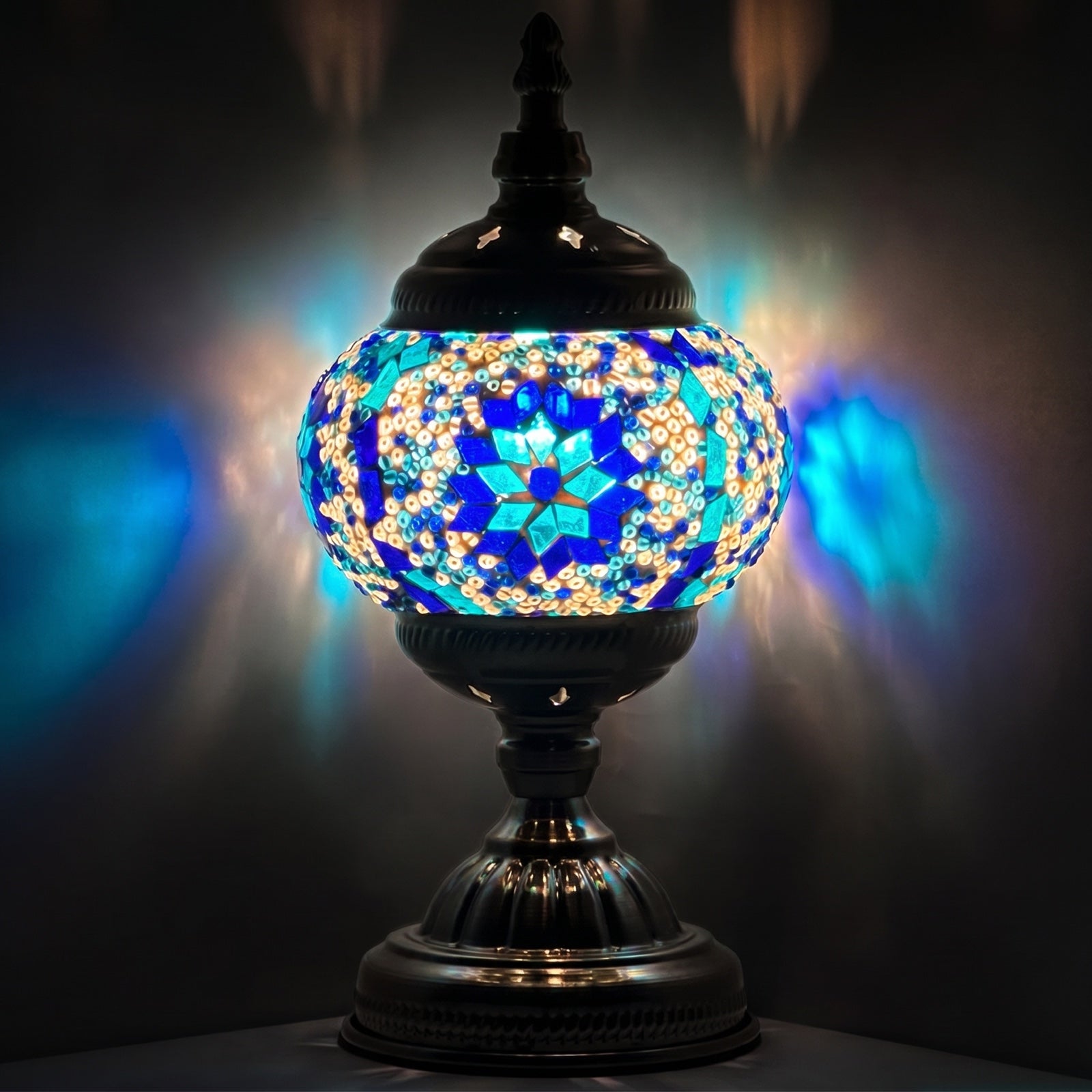 Moroccan mosaic glass table lamp — glowing against a deep charcoal background