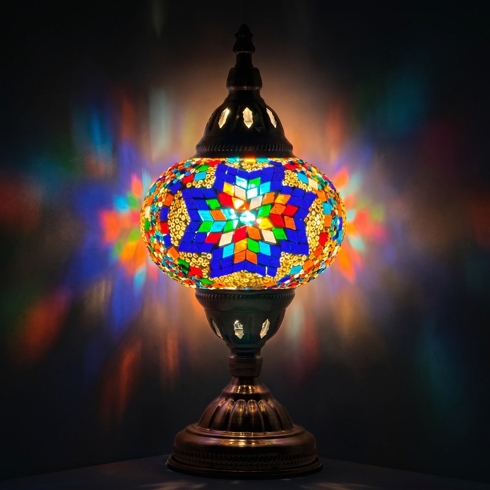 Moroccan Sunset mosaic glass table lamp — glowing against a deep charcoal background