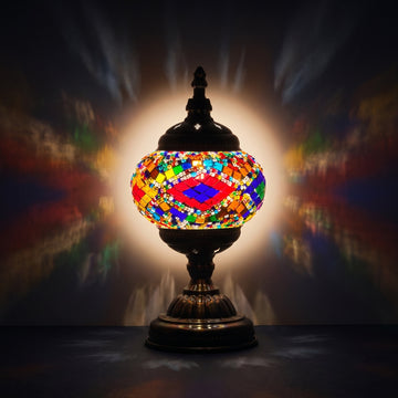 Rainbow Harmony mosaic glass table lamp — glowing against a deep charcoal background