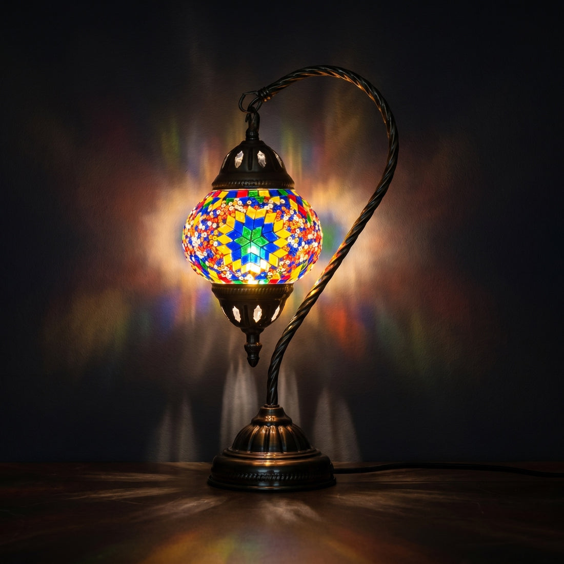Sunbeam Glow mosaic glass table lamp — glowing against a deep charcoal background