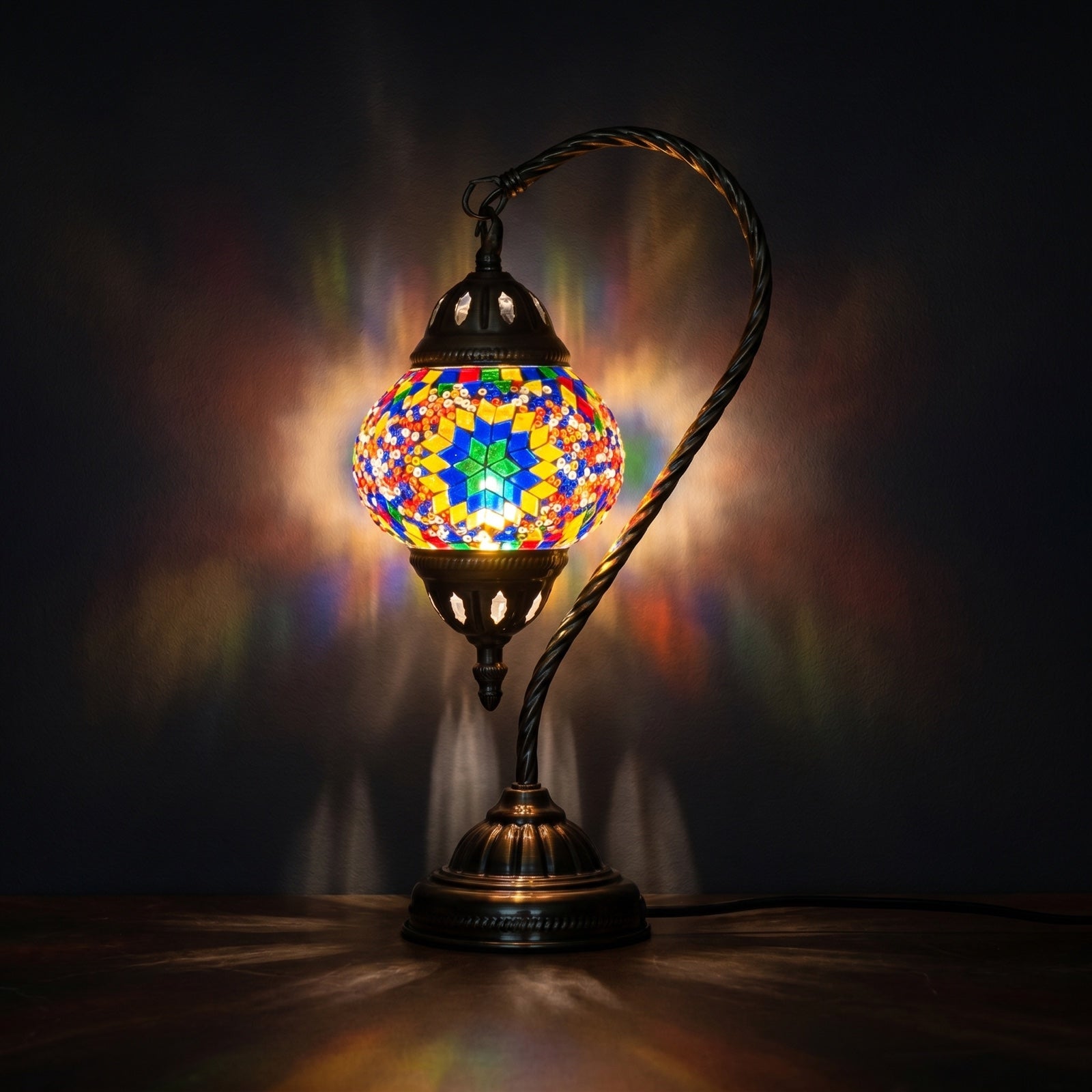 Sunbeam Glow mosaic glass table lamp — glowing against a deep charcoal background