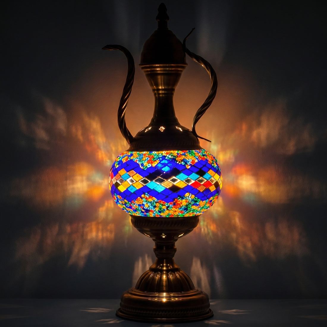 Teapot Treasure mosaic glass table lamp — glowing against a deep charcoal background