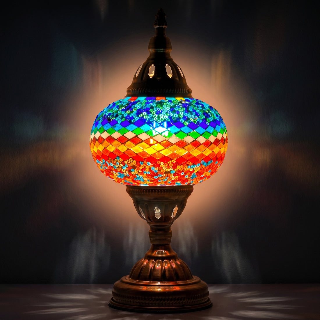 Wave of Colors mosaic glass table lamp — glowing against a deep charcoal background