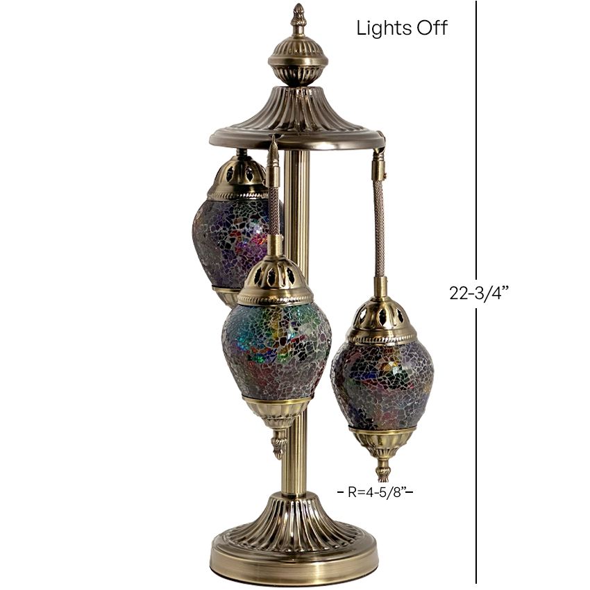 a brass colored lamp with three lights on top of it