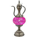 a silver vase with a pink ball on top of it